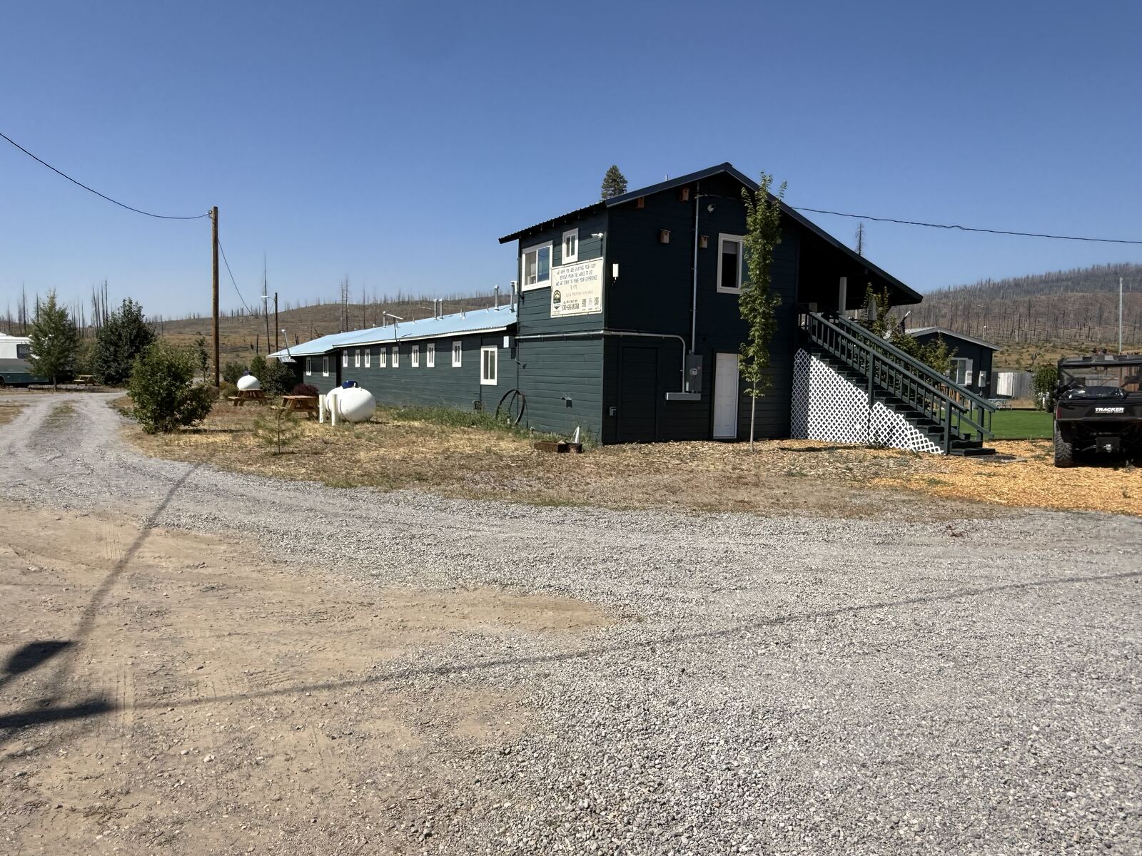The end of the motel at Cedar Lodge: dark green boards, a second floor above the room row, and an outside stair running up to it.